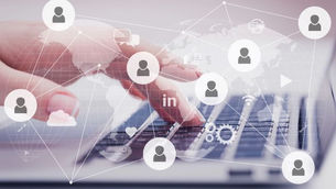 Hand typing on a laptop with overlaid social media icons and network graphics, world map in the background. Text includes "in".