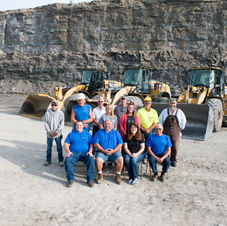 Crew in quarry with three yellow construction loaders