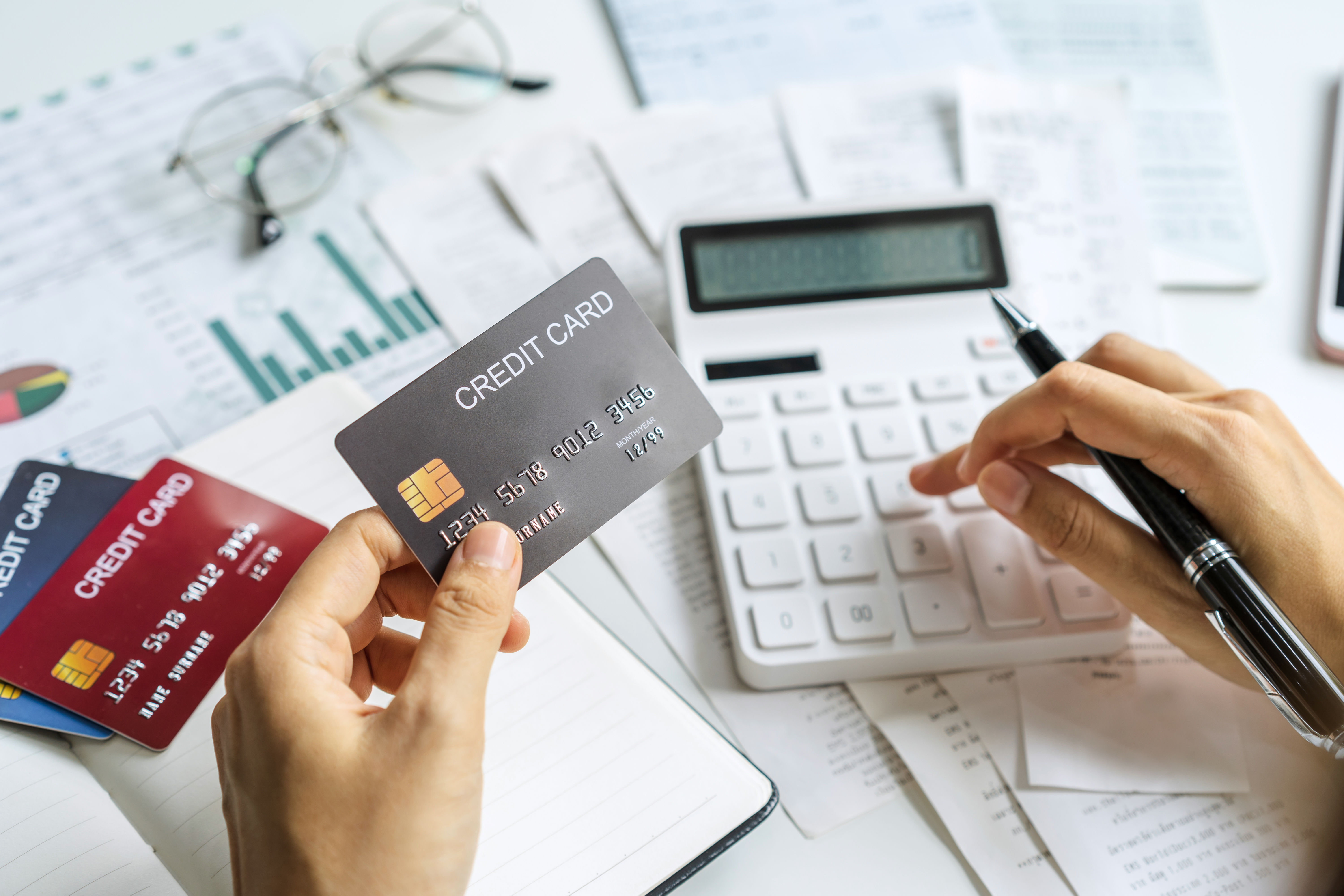 Woman calculating credit card bills with spreadsheets.