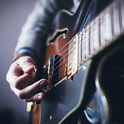 Homem que joga a guitarra