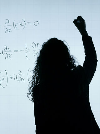 Teen girl doing calculus problems on a white board