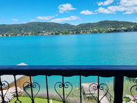 Blick vom Balkon auf türkisblauen See und Berge