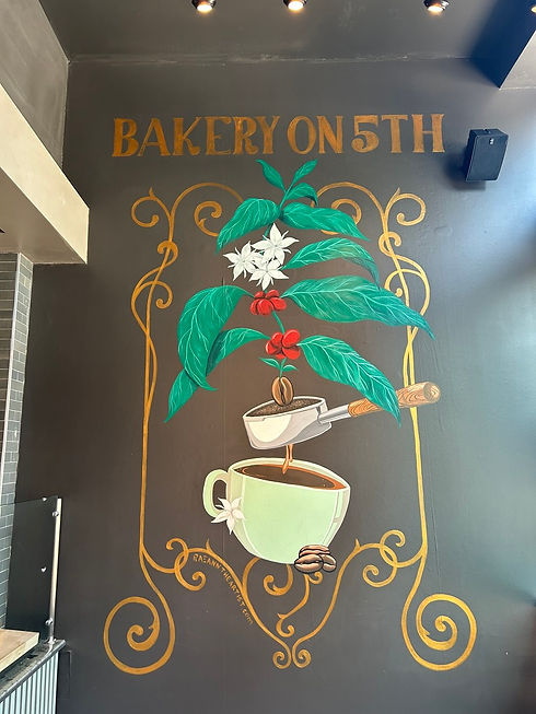 Colorful coffee based mural of the progression of making coffee on a dark wall.