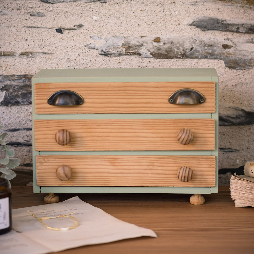 Petite commode à bijoux à trois tiroirs, structure vert sauge, façades en bois naturel, poignées coquilles et boutons en bois
