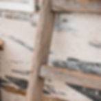 Échelle de grange ancienne en bois patiné utilisée comme porte-serviettes décoratif.