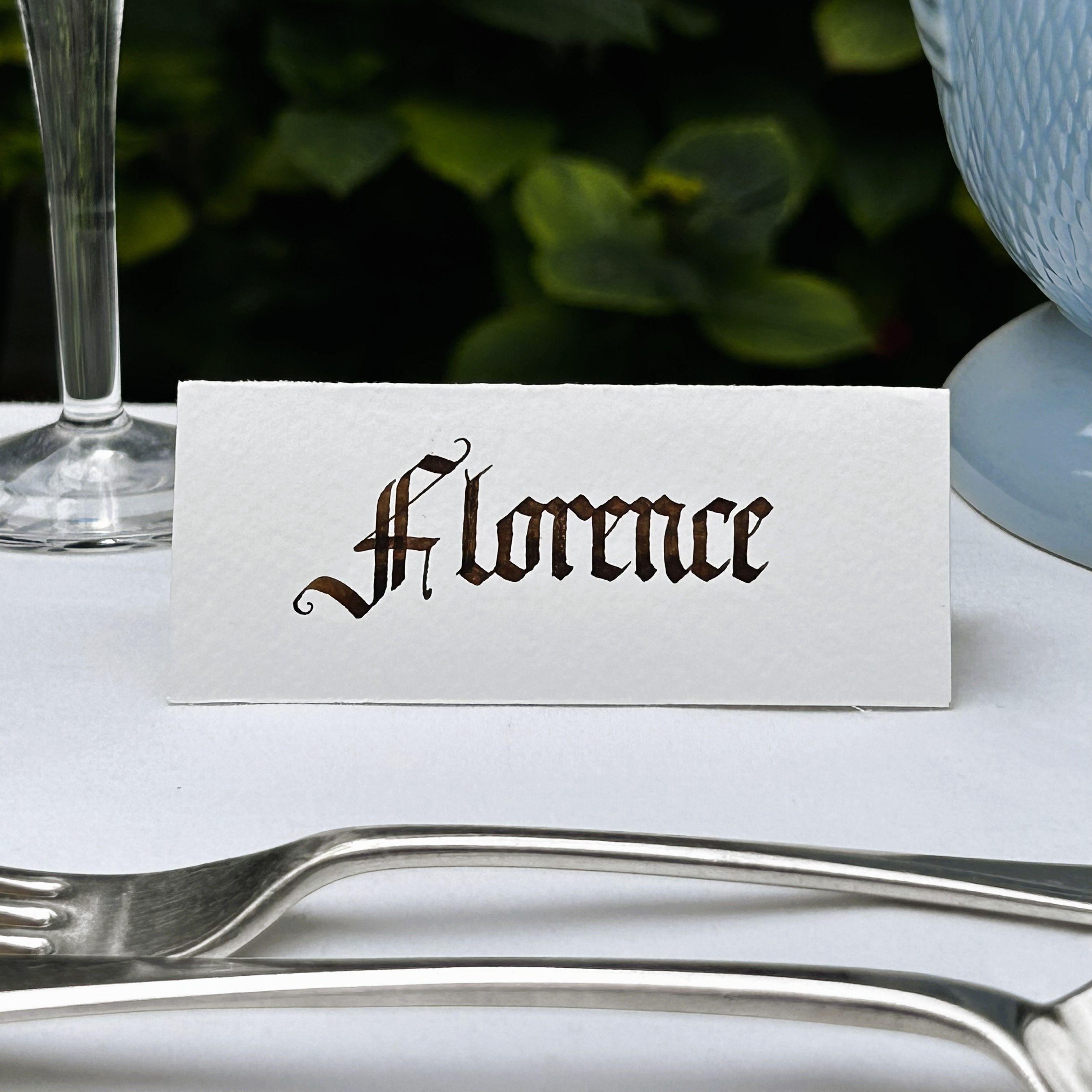 First name illustrated gothic place name card, in brown ink on white textured paper