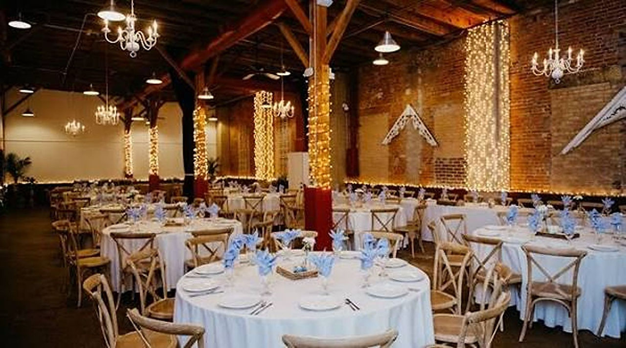 An indoor reception with string lights wrapped around wooden beams at Blumen Gardens
