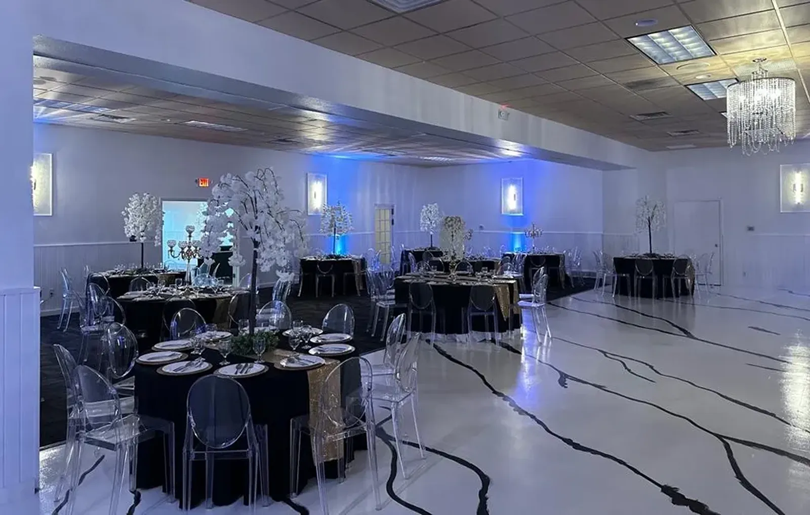 Black covered circle tables on a white and black floor.