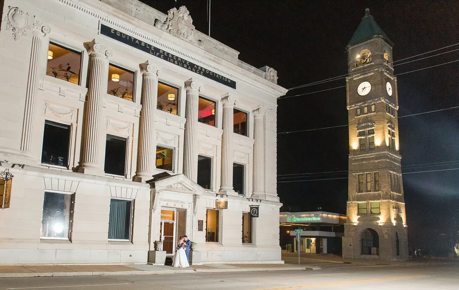 A bride and groom hugging outside the Ballroom at The Reserve at night,