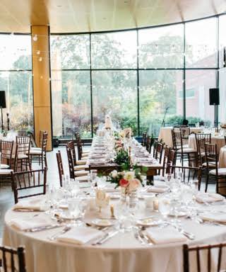 Reception tables with white table clothes and a view of the sunny day at The Morton Arboretum, a Chicago wedding venue