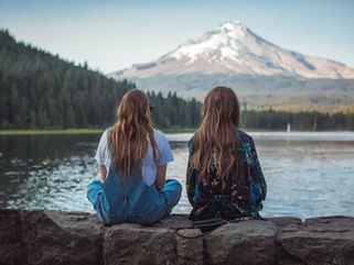Women reconnecting on a lakeside dock