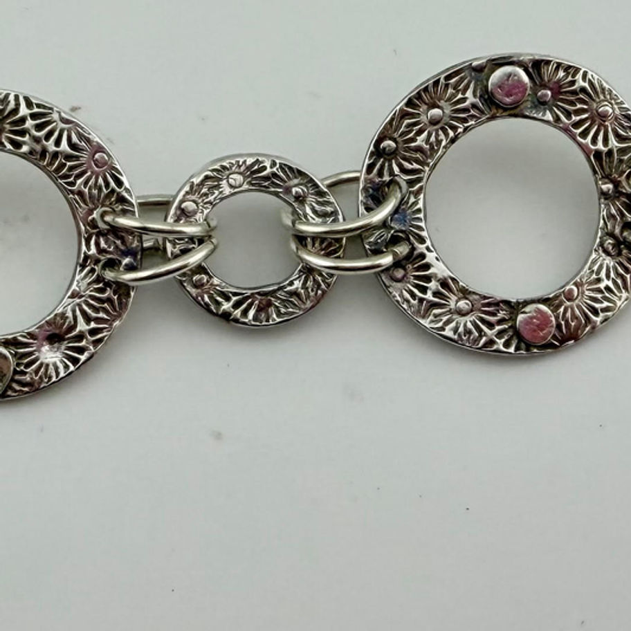Linked Circle Bracelet laid open horizontally displaying connected sterling silver circle links and hook clasp