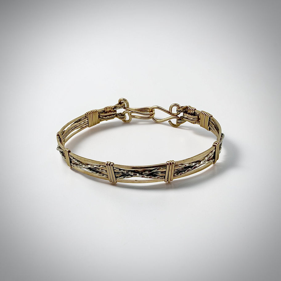 Top angled view of Criss-Cross Bracelet highlighting wrapped gold-filled accents over sterling silver
