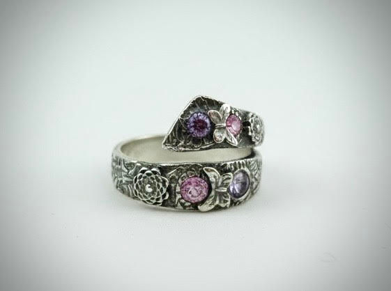 Side view of Sparkle Wrap Ring highlighting sterling silver wrap band and pink cubic zirconia floral details
