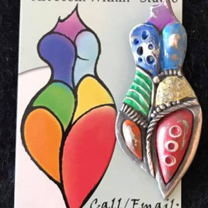 Curvy female form logo with colors of the rainbow next to a piece of silver jewelry with colorful inlay representing the logo of Sil's Art Studio.