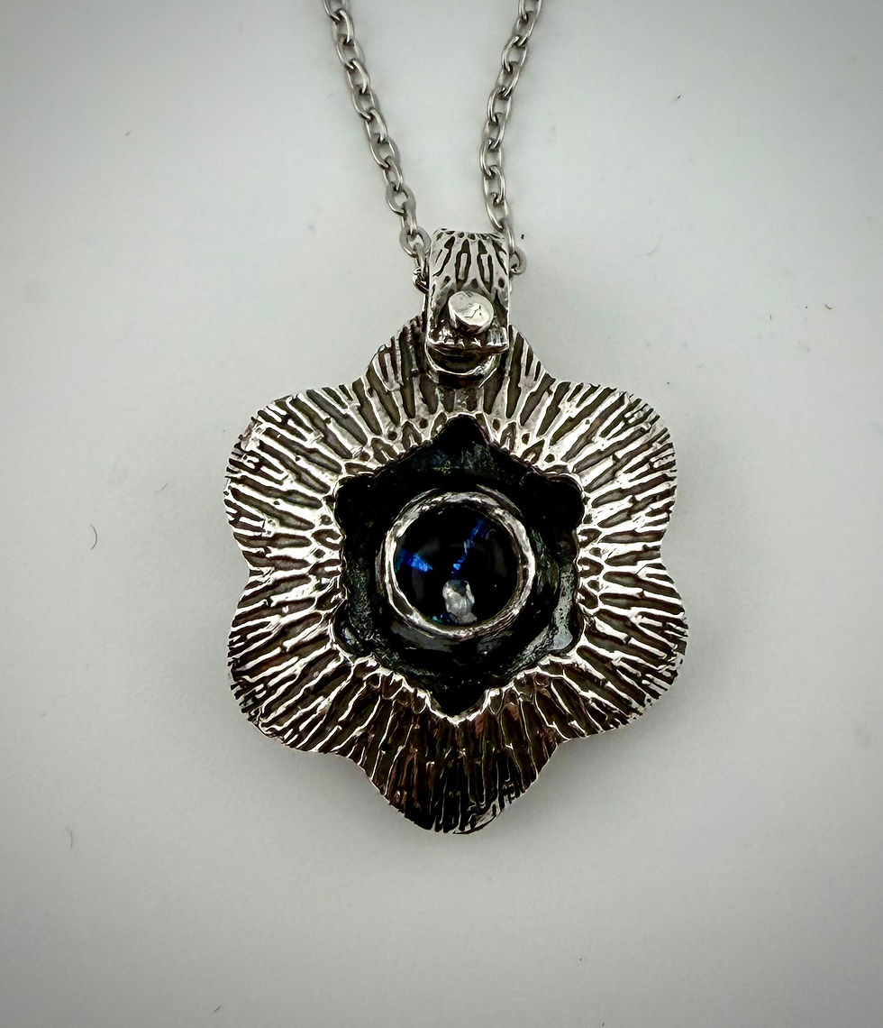Front view of Fascinating Hexagon pendant showing dichroic glass with shimmering blue flecks in silver setting
