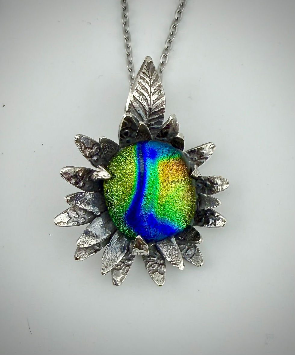 Front view of dichroic glass pendant framed in fine silver petals, showcasing vibrant color-shifting hues.