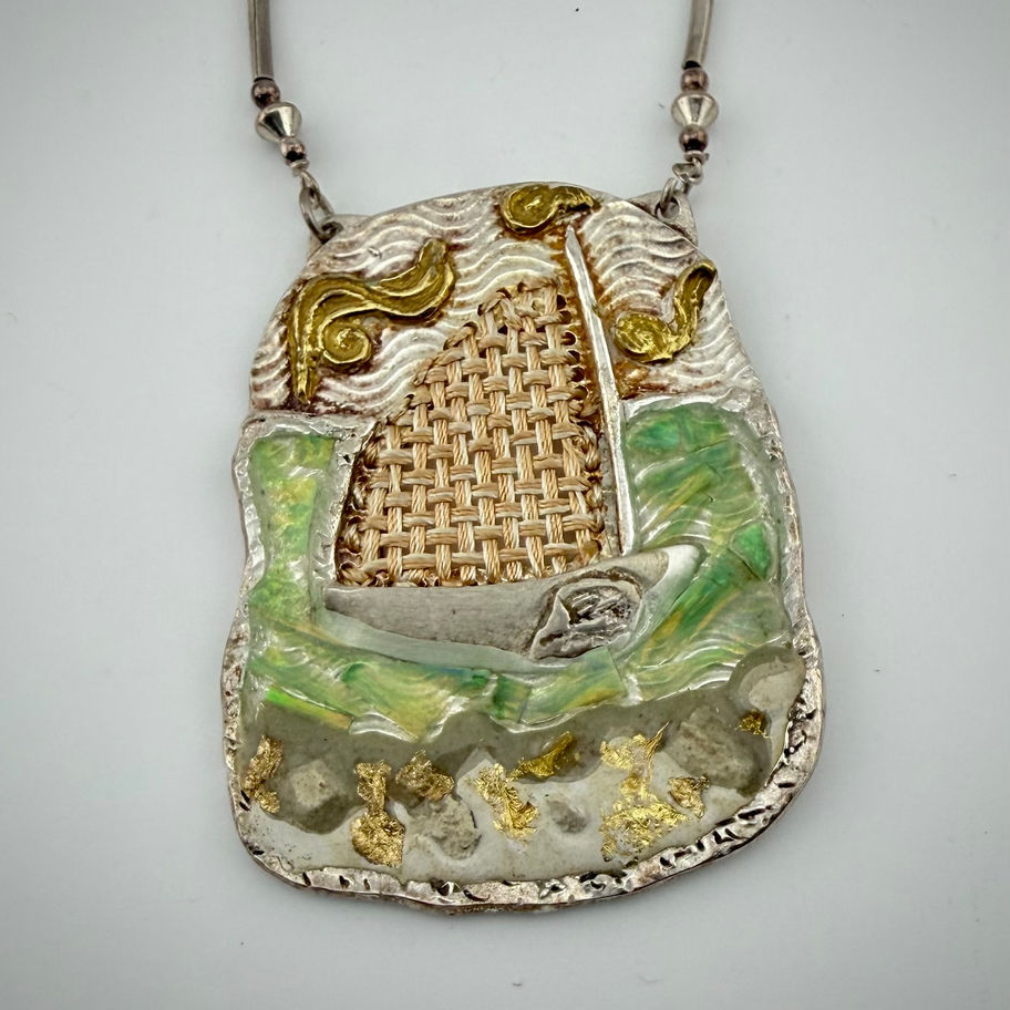 Front view of mixed media necklace with gold and silver sailboat, handwoven sail, textured waves, and opal shards