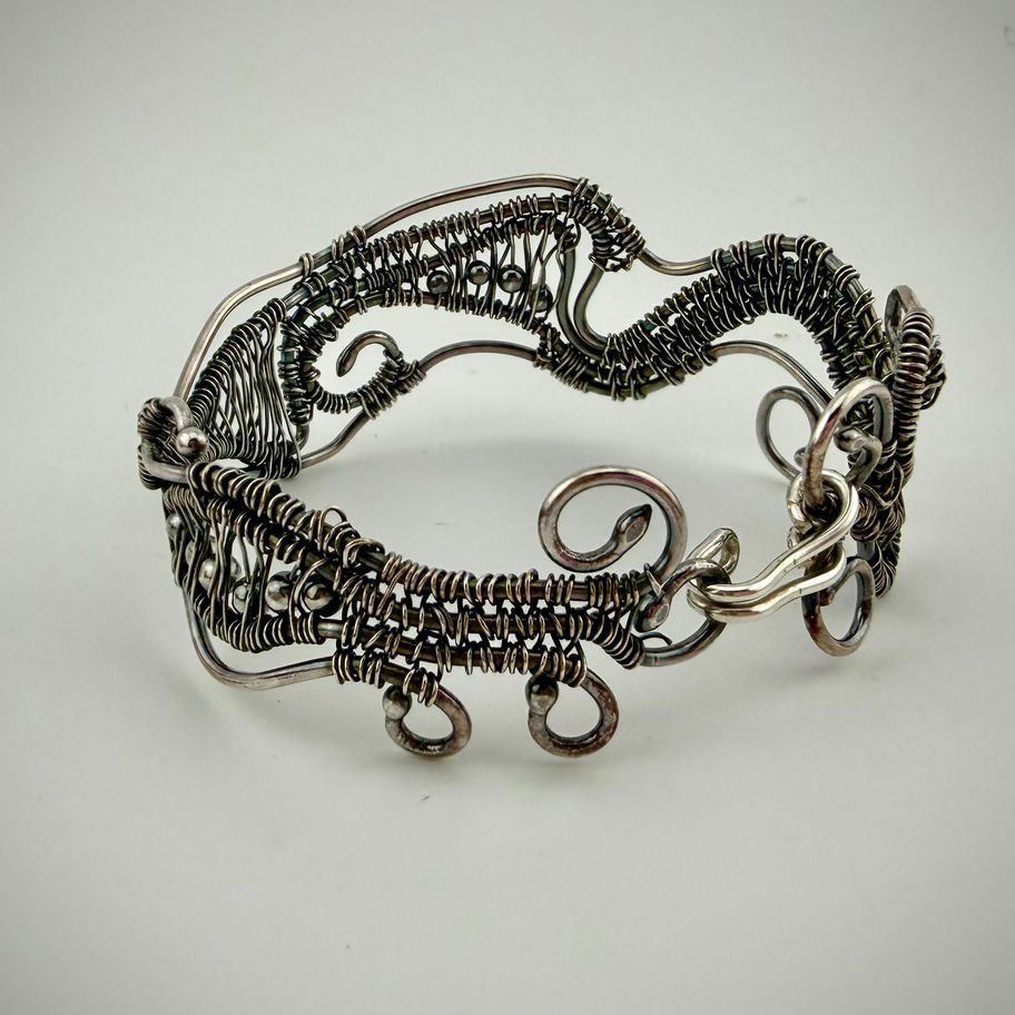 Back view of Swirling Wire Bracelet showing open sterling silver woven structure and handcrafted finish