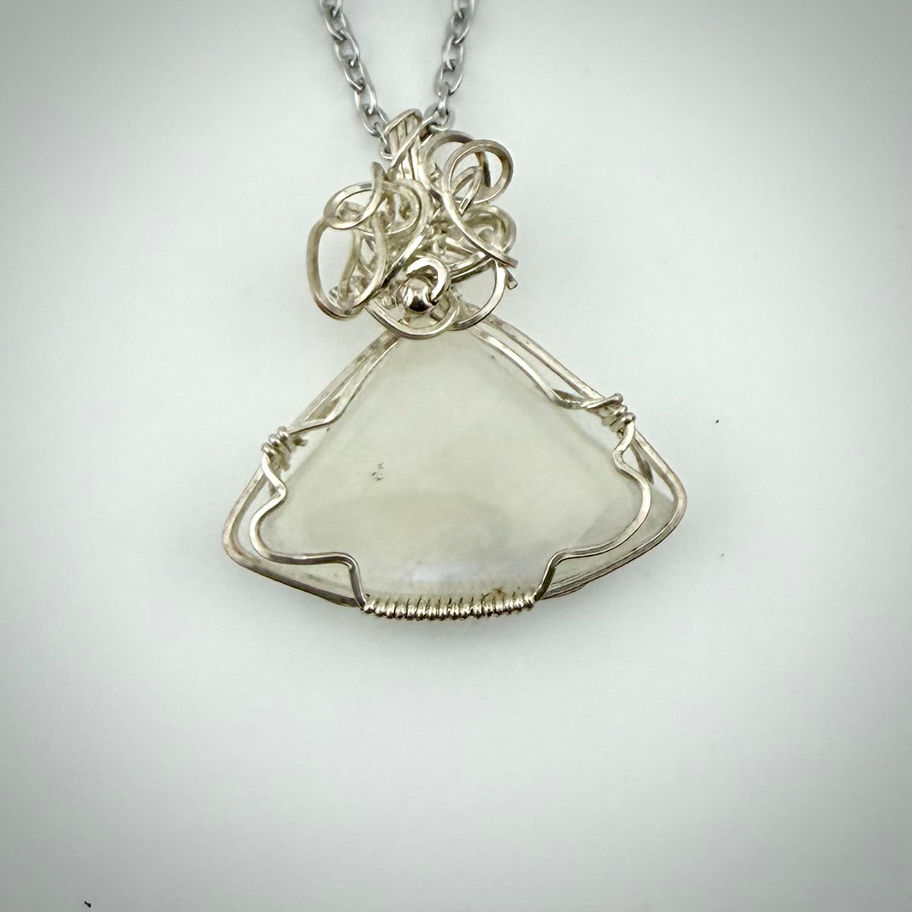 Front view of moonstone pendant, triangular gemstone with moonlight glow set in sterling silver wire with flowing swirl detai