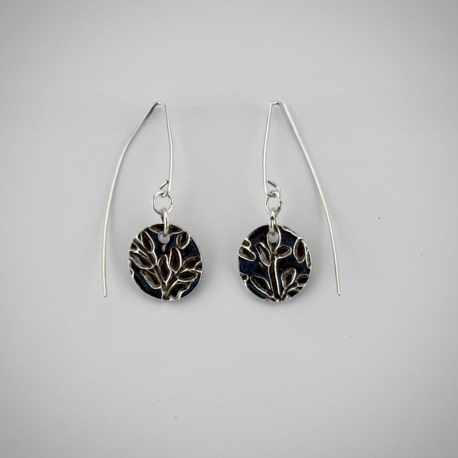 Front view of textured fine silver circle earrings focusing on sterling silver ear wires and hammered finish