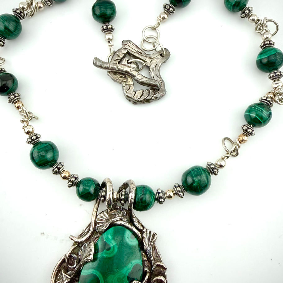 Close-up of Malachite and Ginkgo necklace showing malachite bead chain and sterling silver bead accents