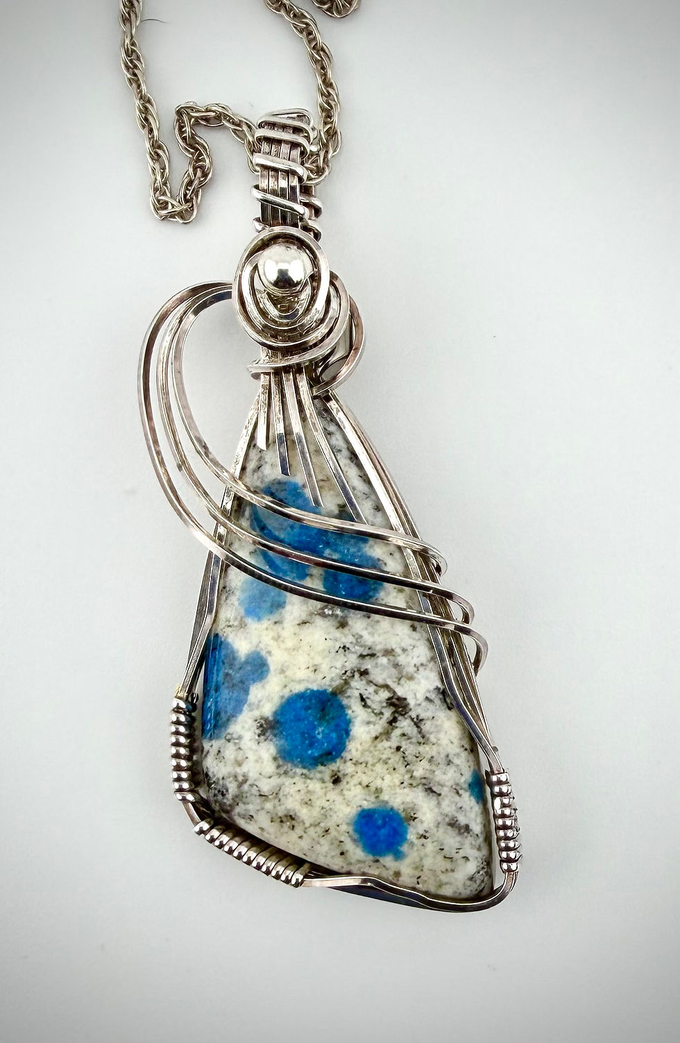 Front view of K2 Jasper pendant featuring blue Azurite dots set in sterling silver wire wrap.