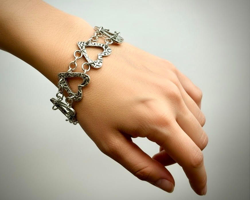 Key to My Heart Bracelet worn on model showing sterling silver linked hearts and romantic key hook clasp detail