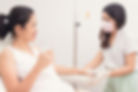 asian nurse giving an IV drip to an asian patient laying in bed