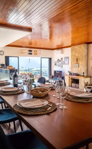 Blue Lake House's spacious living room has a large dining table and a beautiful view of Castelo de Bode Lake, Ferreira do Zêzere. 