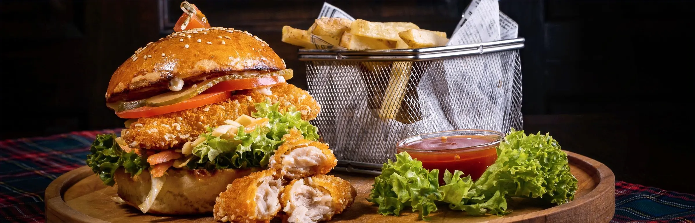 Fish hamburger, french fries and sides.