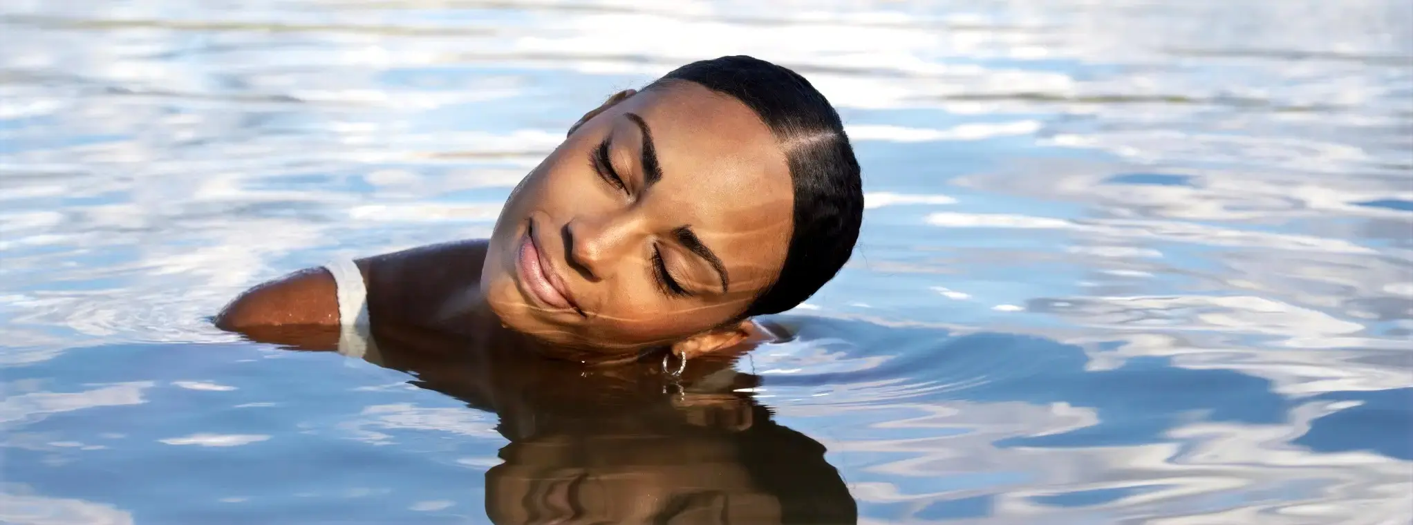 A woman enjoys the warm and pure waters of Castelo de Bode, Ferreira do Zêzere, Portugal.
