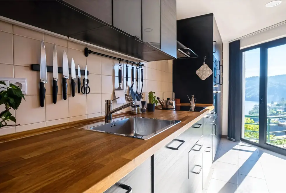 Blue Lake House’s bright kitchen. Large wooden bench and a stunning view of Lago Azul Marina and Castelo de Bode Lake.