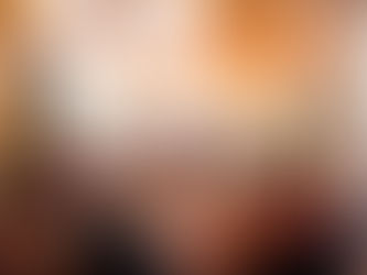 Grupo de oito pessoas reunidas à mesa de jantar em ambiente natalício acolhedor, com decoração festiva, luzes pendentes e árvores de Natal iluminadas. A mesa de madeira está posta com pratos, copos e comida, sugerindo uma refeição comemorativa em família.