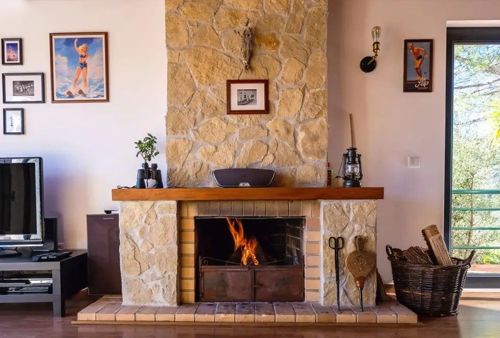 Wood burning in the rustic stone fireplace of the Blue Lake House at Castelo de Bode Lake, Ferreira do Zêzere, Portugal.