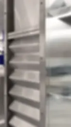 Détail d’une structure en inox brossé avec éléments nervurés et vitrines intégrées, illustrant une esthétique industrielle et fonctionnelle.