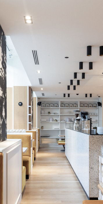 Dans ce projet d’architecture intérieure, nous avons créé un coffee shop de 100 m² pour la marque SEASON, alliant design moderne et matériaux raffinés. Chaque détail a été pensé pour offrir une expérience client unique et immersive. L'espace présente des éléments sur mesure, avec des bancs en tissu côtelé, des murs en marbre emblématique signé Mathias Kiss, et des tables en terrazzo. Cet espace retail a été conçu pour offrir une atmosphère chaleureuse et accueillante, favorisant la détente et l’échange. Nous avons intégré des solutions sur mesure pour créer un lieu fonctionnel et esthétique, où le design et la fonctionnalité se rencontrent pour répondre aux besoins d’un coffee shop moderne