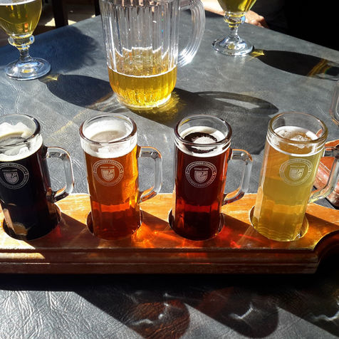 Beer flight with five different craft beers on a paddle
