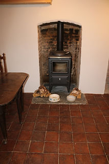 Wood burning stove installation on terracotta tiles Grade 2 listed farmhouse Mylor