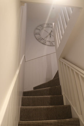 Clock in decorated stairwell, Porth beach.jpg