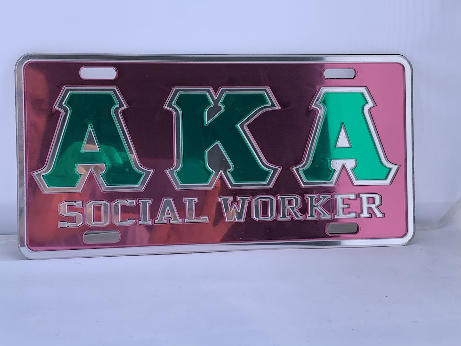 AKA SOCIALWORKER LICENSE PLATE PINK BACKGROUND GREEN LETTERS MIRROR OUTLINE