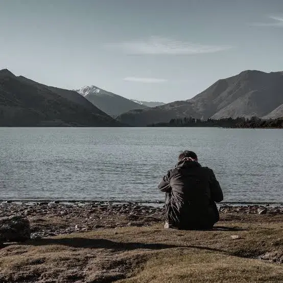 man on lake shore alone