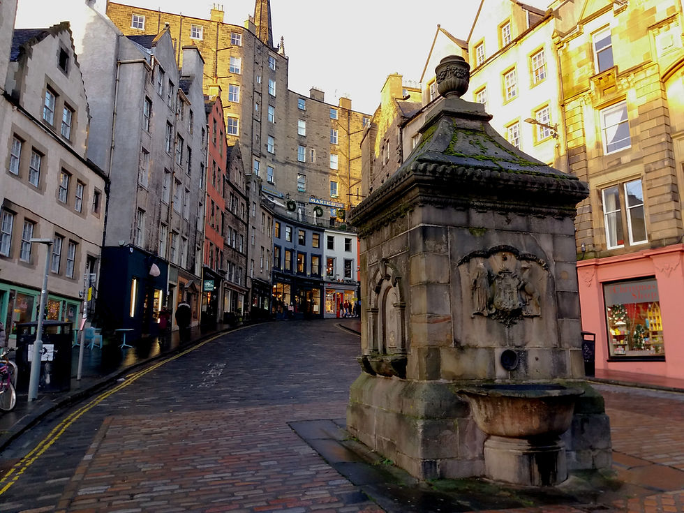The rolling upward curve of Victoria Street with it's cobblestones and colourful shop fronts. There is also a large decorative water well.