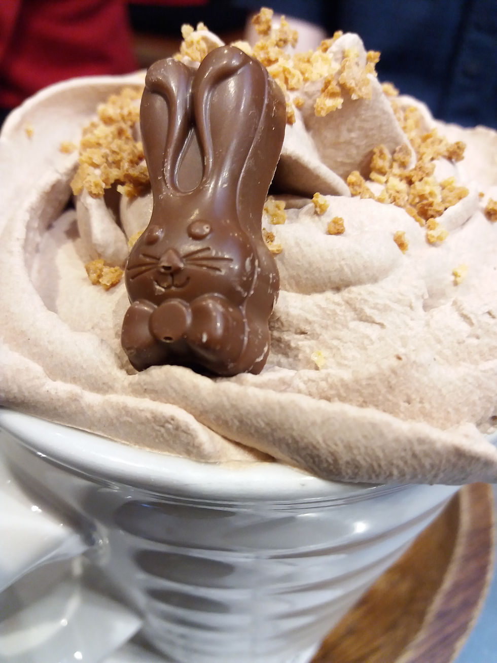 Hot chocolate with chocolate bunny chocolate whipped cream and nuts