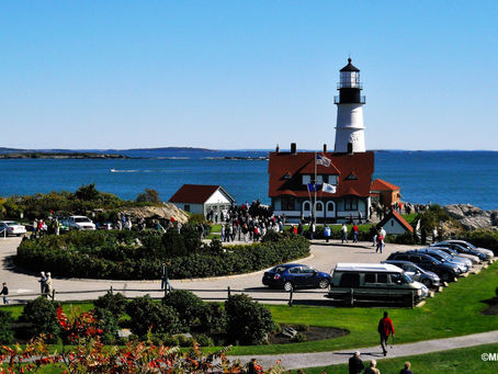 Coastal lighthouse in Maine in front of clear blue waters of the Atlantic