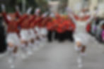 Majorettes on parade in there white and red outfits.