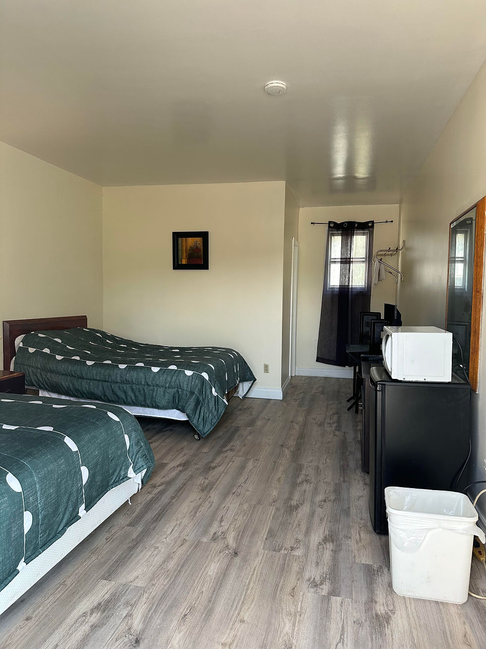 Two double beds, a table with chairs, microwave, TV, and fridge