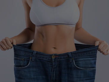 Woman after weight loss trying to hold her jeans.