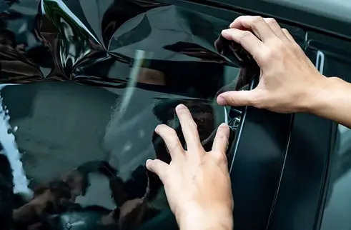 Spécialiste en train de faire la post de vitres teintées sur une voiture, près de Nantes