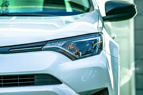 Zoom sur le phare d'une voiture blanche